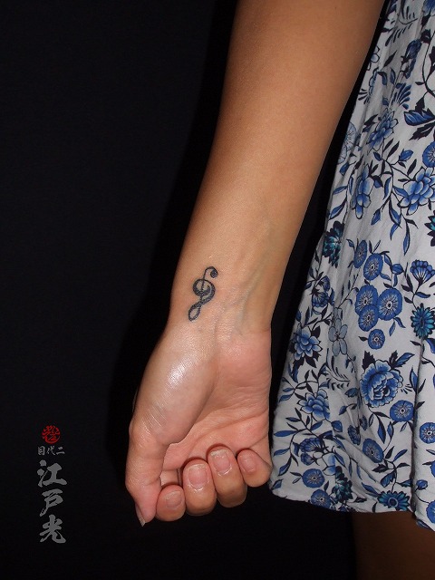 女性の手首に音符のタトゥー