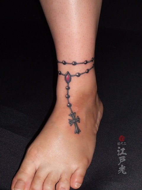 女性の足首にアンクレット、十字架、クロスの刺青タトゥー
